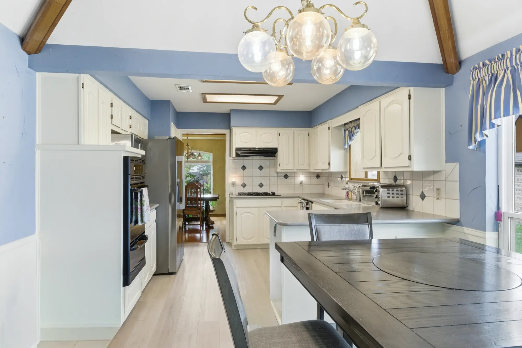 Kitchen with white cabinetry and vaulted ceiling
